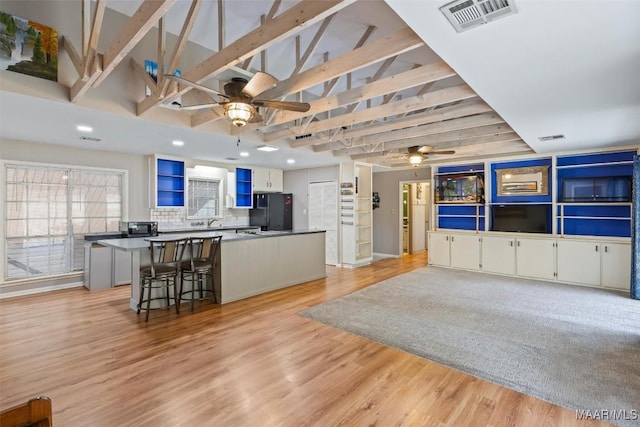 kitchen featuring visible vents, white cabinets, dark countertops, a kitchen island, and black appliances