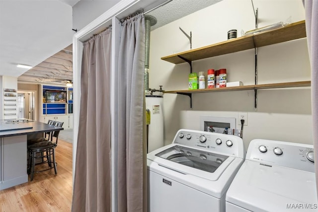 laundry area with laundry area, light wood-style floors, gas water heater, and washer and dryer