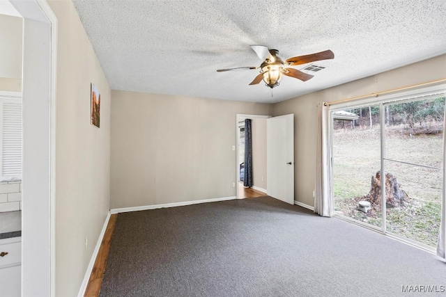 carpeted spare room featuring a ceiling fan, visible vents, a textured ceiling, and baseboards