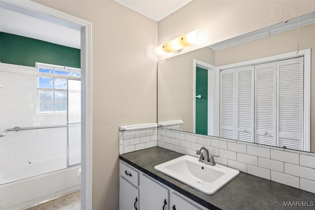 bathroom featuring tasteful backsplash, vanity, toilet, and bath / shower combo with glass door