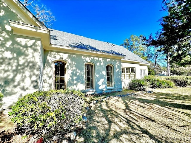 view of front of house featuring roof with shingles and stucco siding