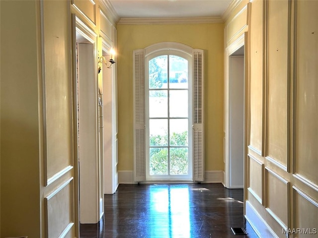 doorway to outside with a healthy amount of sunlight, baseboards, ornamental molding, and dark wood finished floors