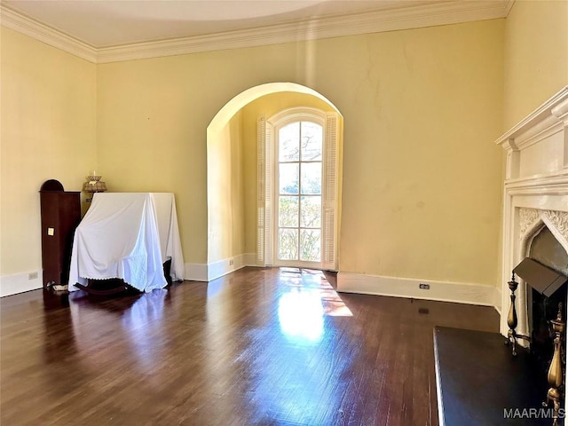 living area with baseboards, arched walkways, dark wood-style flooring, crown molding, and a fireplace