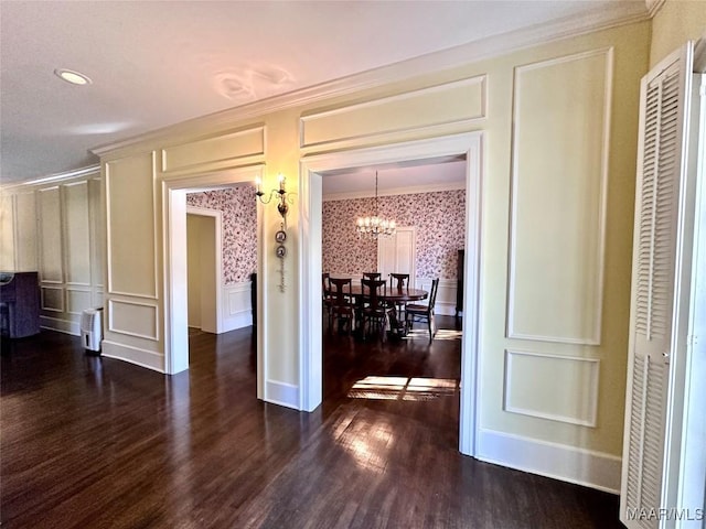 interior space with wallpapered walls, ornamental molding, dark wood finished floors, and a decorative wall