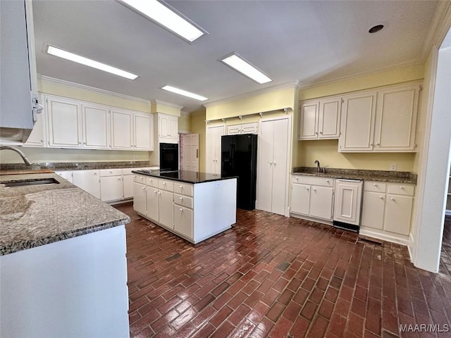 kitchen featuring black appliances, a kitchen island, white cabinetry, and a sink