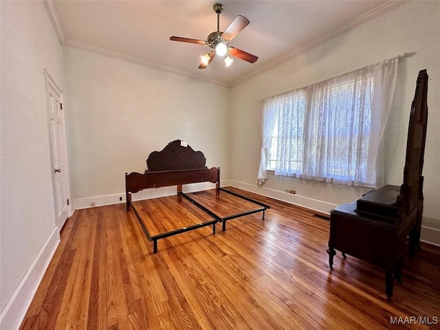 interior space featuring visible vents, ornamental molding, ceiling fan, wood finished floors, and baseboards