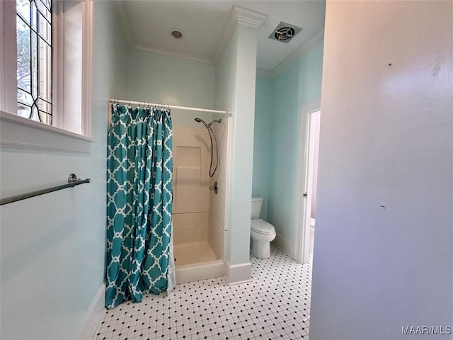 bathroom featuring toilet, a stall shower, baseboards, and ornamental molding