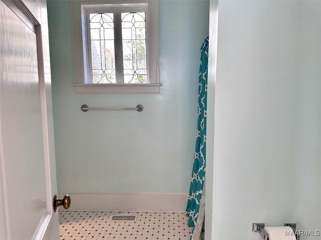 bathroom featuring baseboards, visible vents, and tile patterned floors