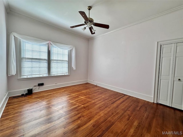 unfurnished bedroom featuring a ceiling fan, baseboards, crown molding, and wood finished floors