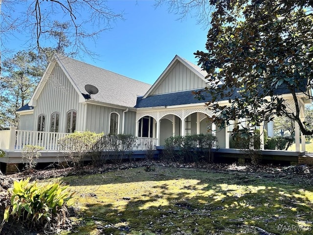 view of front of property featuring a shingled roof, board and batten siding, and a front yard