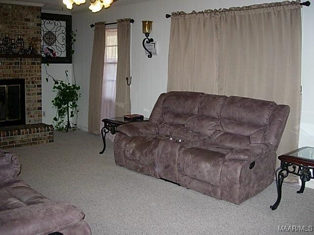 living room with carpet and a brick fireplace