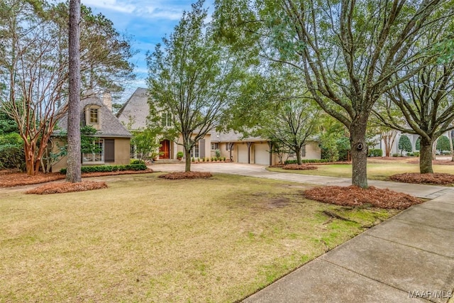 view of front of house featuring concrete driveway, a front lawn, and stucco siding