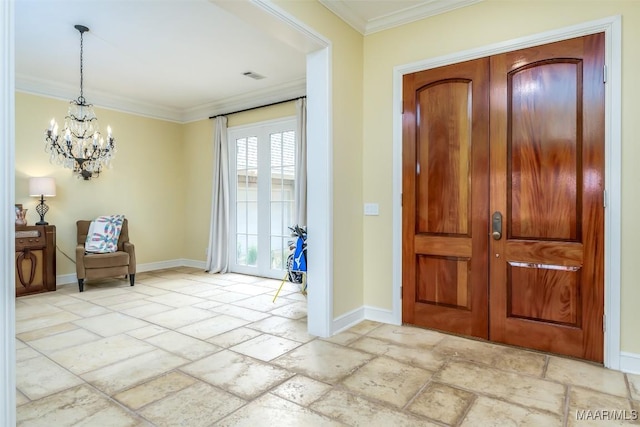 entrance foyer featuring ornamental molding, stone tile flooring, a chandelier, and baseboards