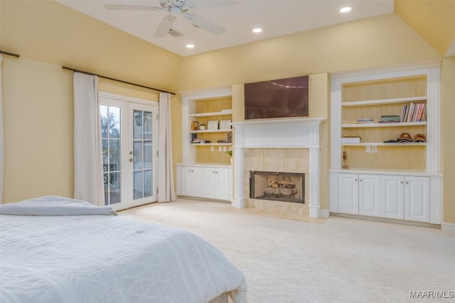 bedroom featuring light carpet, a fireplace, vaulted ceiling, access to outside, and french doors