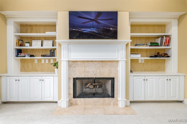 interior details featuring built in shelves, carpet, and a tile fireplace