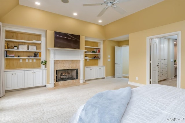 bedroom with light carpet, recessed lighting, a fireplace, and baseboards