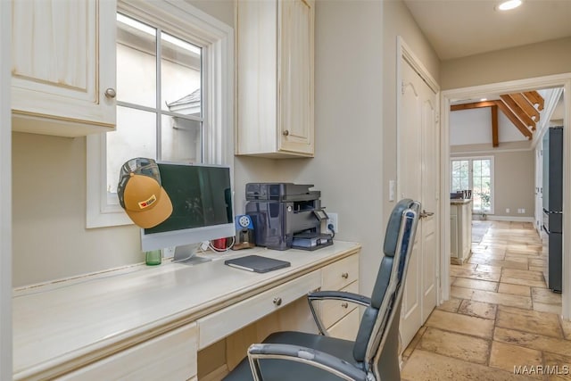 office space featuring built in desk, baseboards, stone tile flooring, and recessed lighting