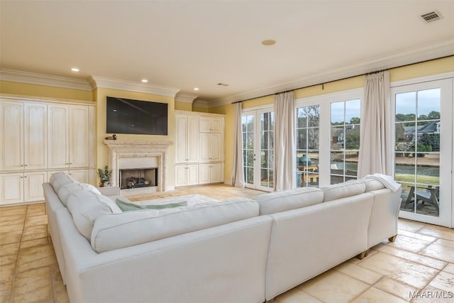 living area featuring stone tile floors, recessed lighting, a fireplace, visible vents, and ornamental molding