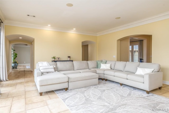 living room with arched walkways, baseboards, visible vents, and crown molding