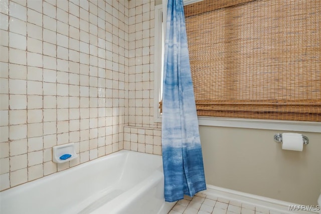 bathroom featuring shower / bath combo, baseboards, and tile patterned floors