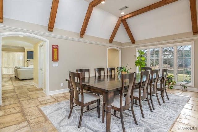 dining room with lofted ceiling with beams, stone tile floors, visible vents, and arched walkways