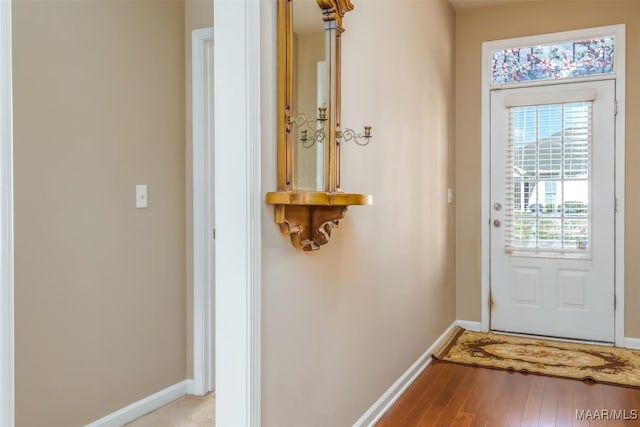 doorway to outside with light wood-style flooring and baseboards