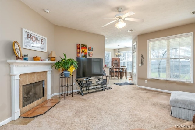 carpeted living room with baseboards, a fireplace, and visible vents