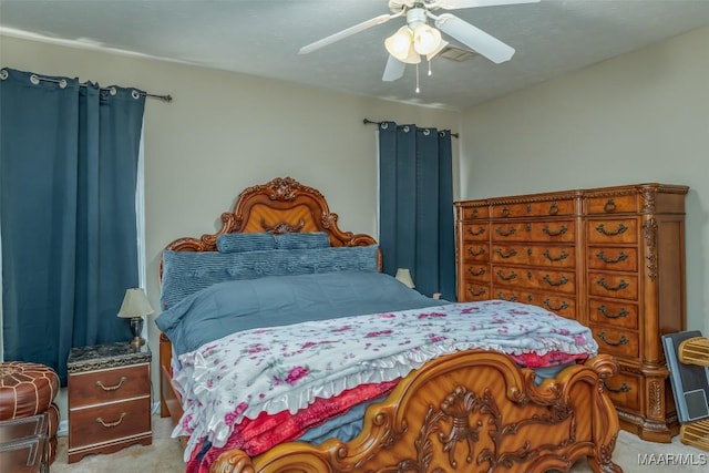 bedroom featuring a ceiling fan, light carpet, and visible vents