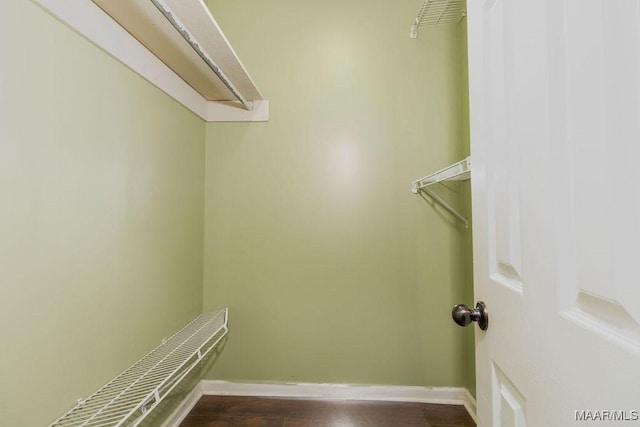 spacious closet with dark wood-style flooring