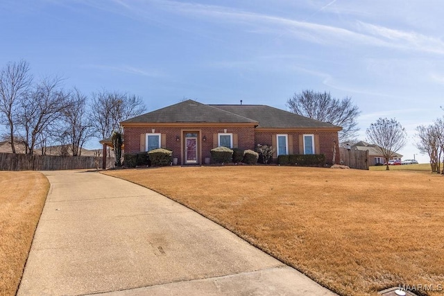 ranch-style house featuring brick siding, a front yard, and fence