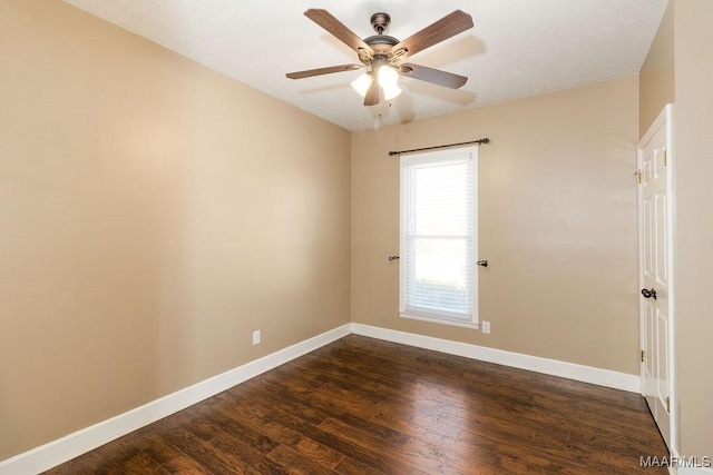 spare room with a ceiling fan, baseboards, and dark wood-style flooring