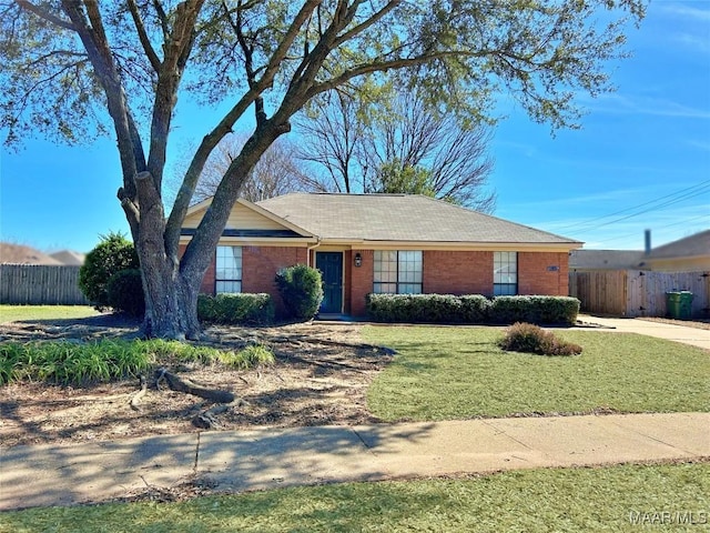 ranch-style home with brick siding, a front yard, and fence