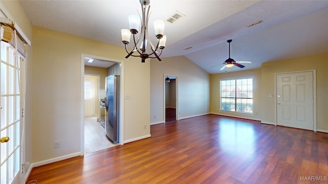 empty room featuring dark wood-type flooring, visible vents, vaulted ceiling, and baseboards