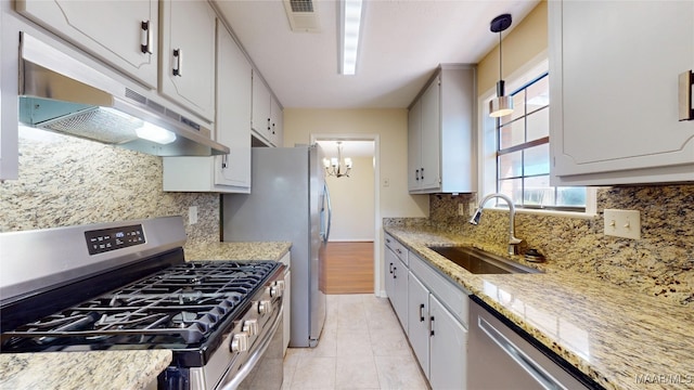 kitchen featuring hanging light fixtures, appliances with stainless steel finishes, white cabinetry, a sink, and under cabinet range hood