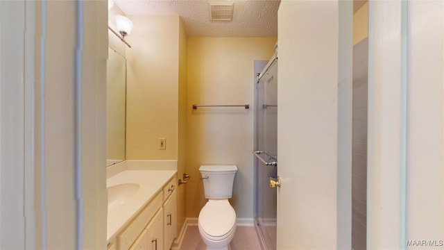 bathroom with visible vents, toilet, a shower with shower door, a textured ceiling, and vanity