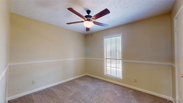 carpeted spare room featuring ceiling fan, a textured ceiling, and baseboards