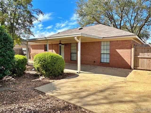 rear view of house featuring fence, a patio, and brick siding