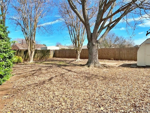 view of yard featuring a fenced backyard, an outdoor structure, and a shed