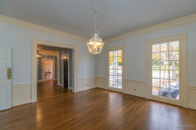 unfurnished dining area featuring a wainscoted wall, crown molding, and dark wood-style flooring
