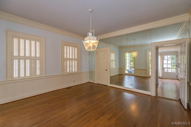empty room featuring dark wood-style floors, ornamental molding, and baseboards