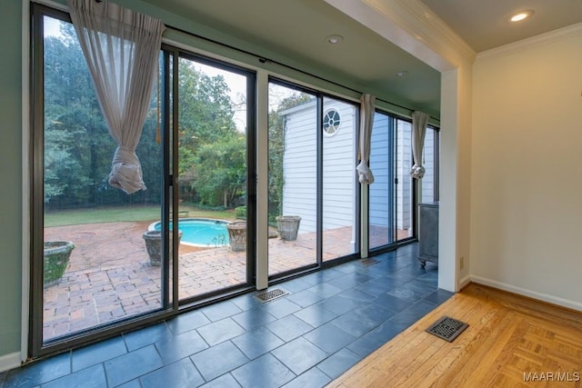 doorway to outside with ornamental molding, recessed lighting, visible vents, and baseboards