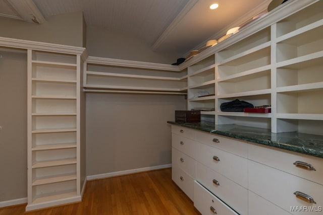 walk in closet with vaulted ceiling and light wood finished floors