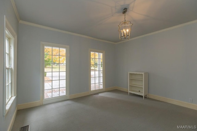 carpeted empty room with visible vents, crown molding, baseboards, and an inviting chandelier