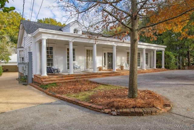 neoclassical / greek revival house with a porch and roof with shingles