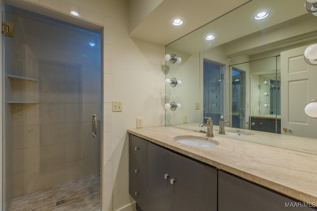 bathroom with a stall shower, recessed lighting, and vanity