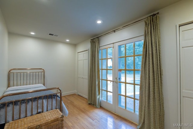 bedroom featuring french doors, visible vents, light wood finished floors, and multiple windows