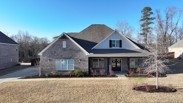 craftsman-style house with brick siding, a porch, and a front yard