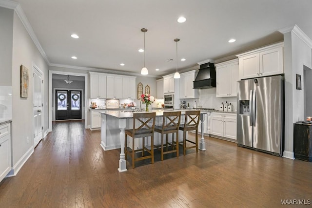 kitchen featuring white cabinetry, stainless steel refrigerator with ice dispenser, decorative light fixtures, and custom range hood