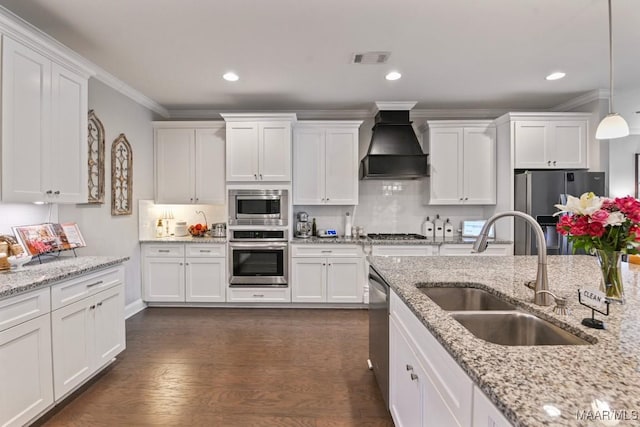 kitchen featuring white cabinetry, custom exhaust hood, stainless steel appliances, and a sink