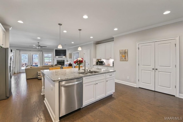 kitchen featuring a sink, white cabinetry, open floor plan, appliances with stainless steel finishes, and an island with sink